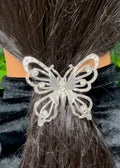 Close-up of silver butterfly ponytail hair hook with rhinestones securing ponytail
